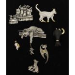 A Swarovski crystal set walking cat brooch, gilded paw, tail and ears, swan mark; and other cat form