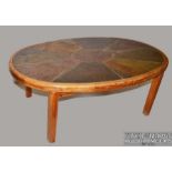 A Haslev (Danish) oval oak frame coffee table, the top inset with natural stone, circular metal disc