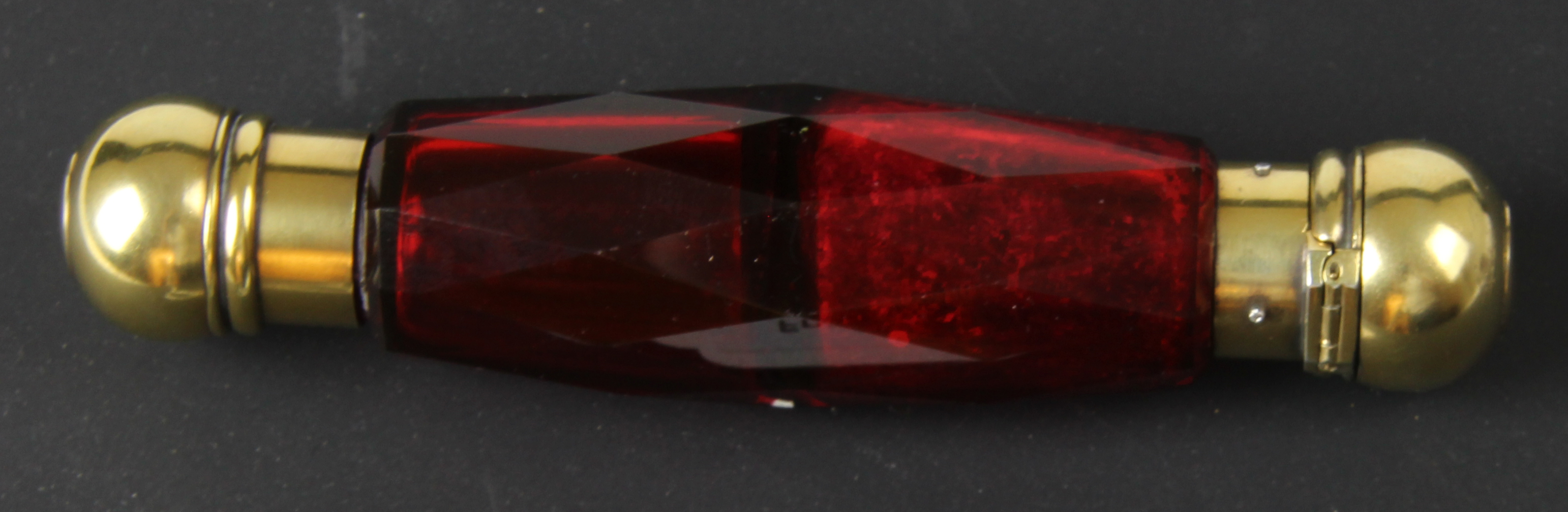 An unusual late 19thC ruby coloured faceted glass and gold and silver gilt double ended scent