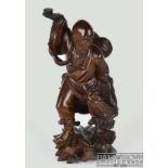 A Chinese carved wood figure of an Immortal subduing a Kylin, inlaid glass eyes and teeth of