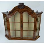 A Dutch bow fronted wall cabinet, the arched top with foliate pediment over two glazed doors, 69cm