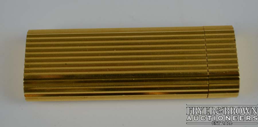 A Cartier gold plated vertical lined lighter marked Cartier Paris 06972K - Swiss made
