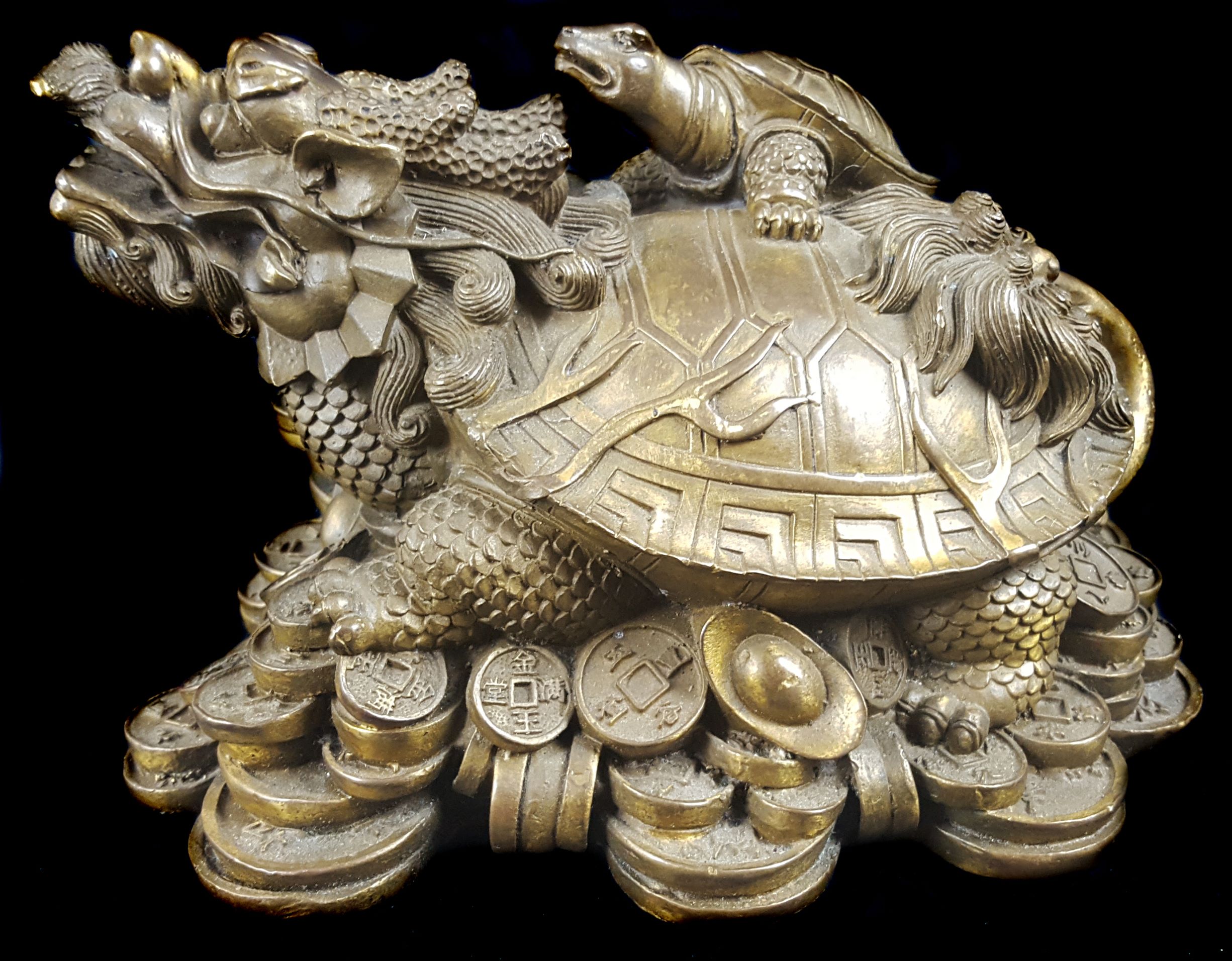 A Chinese Yuanbao coin gilded figural bronze, cast as a Bixi dragon turtle on a pile of couuns and