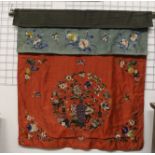 A Chinese silk door curtain, the main panel of red silk embroidered in polychrome colours with a