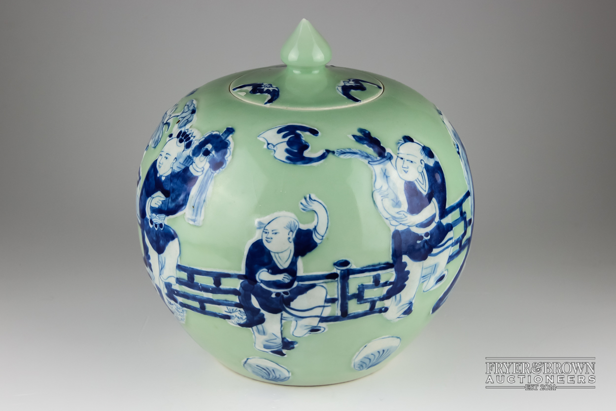 A Chinese porcelain celadon ground blue and white jar and cover, globular decorated with figures,