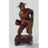 A Chinese carved wood figure of a fisherman with net, holding a net under one arm, a basket on a
