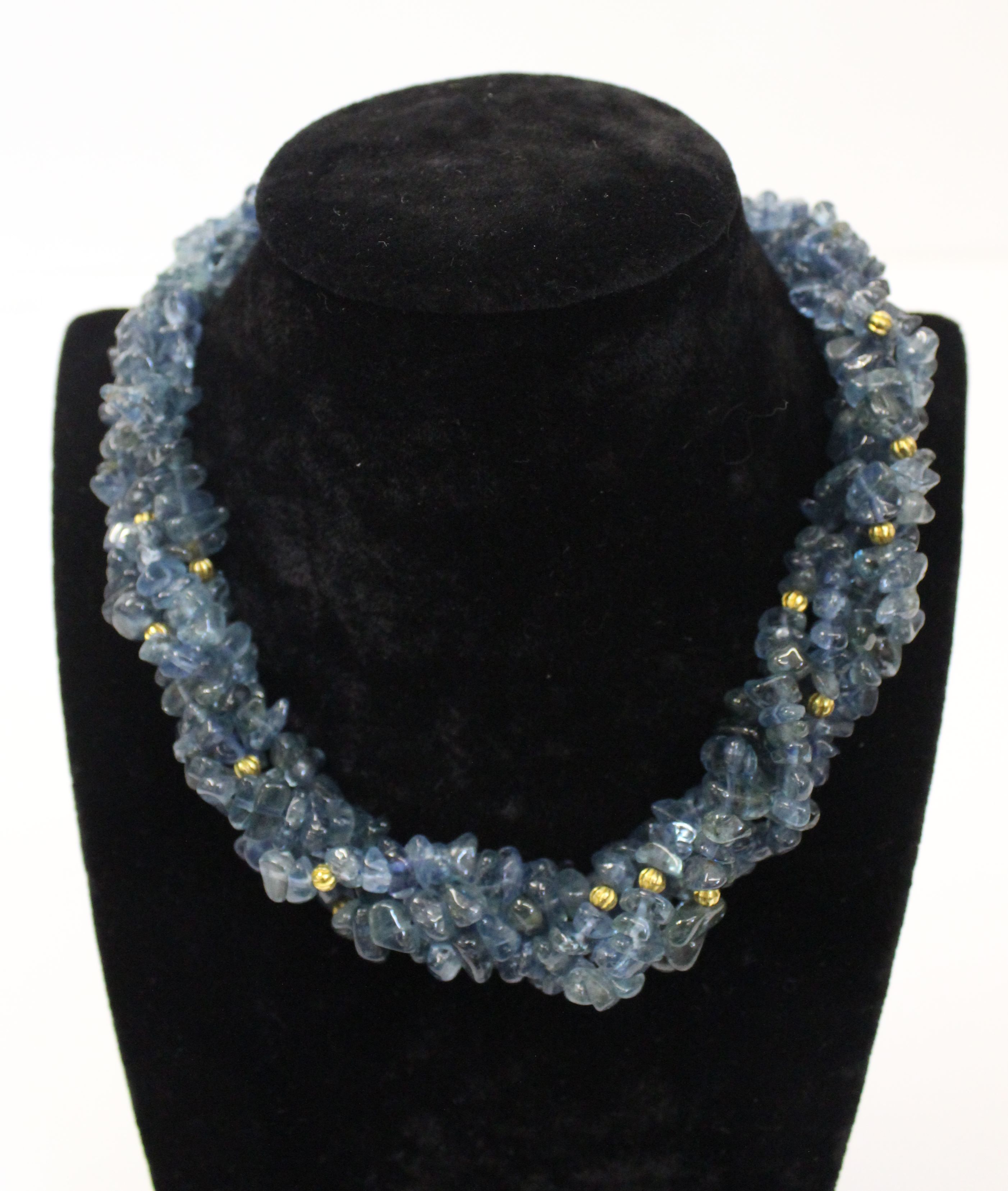 An unusual aquamarine, blue topaz and gold roundell necklace, the four rows of graduated natural