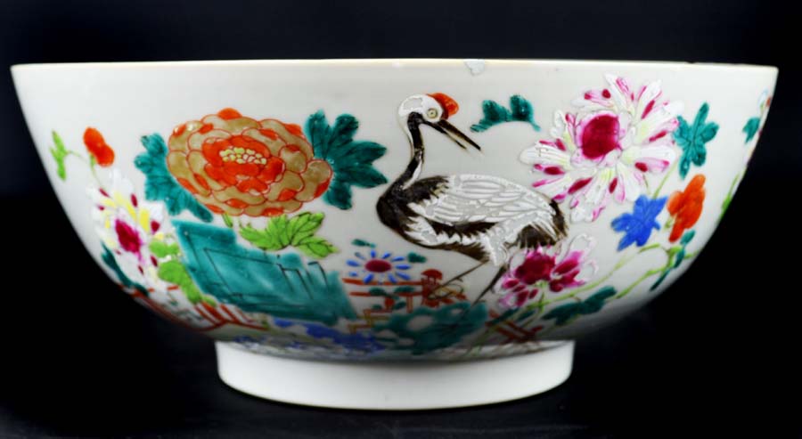 A Chinese export porcelain bowl, painted in famille rose enamels, with cranes amid a fenced