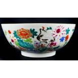 A Chinese export porcelain bowl, painted in famille rose enamels, with cranes amid a fenced