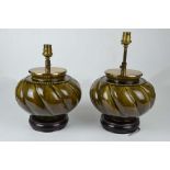 A pair of Continental pottery lamp bases, dark green glazed, of ribbed globular form, fitted for