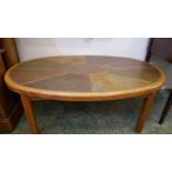 A Haslev (Danish) oval oak frame coffee table, the top inset with natural stone, circular metal disc