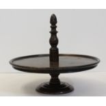 A mahogany lazy Susan, circular with turned wood central handle, under an acorn finial, 33cm diam