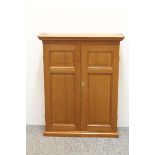 A small vintage pine wall cupboard, two panelled doors opening onto two fixed shaped plate