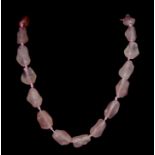 A Chinese slightly graduated row of 29 baroque shaped rose quartz beads on a silver gilt clasp