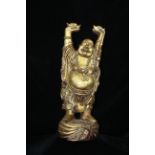 A Chinese carved and gilded wood figure, of the happy Buddha holding sychee aloft, probably early