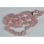 A Chinese slightly graduated row of 29 Baroque shaped rose quartz beads on a silver gilt clasp