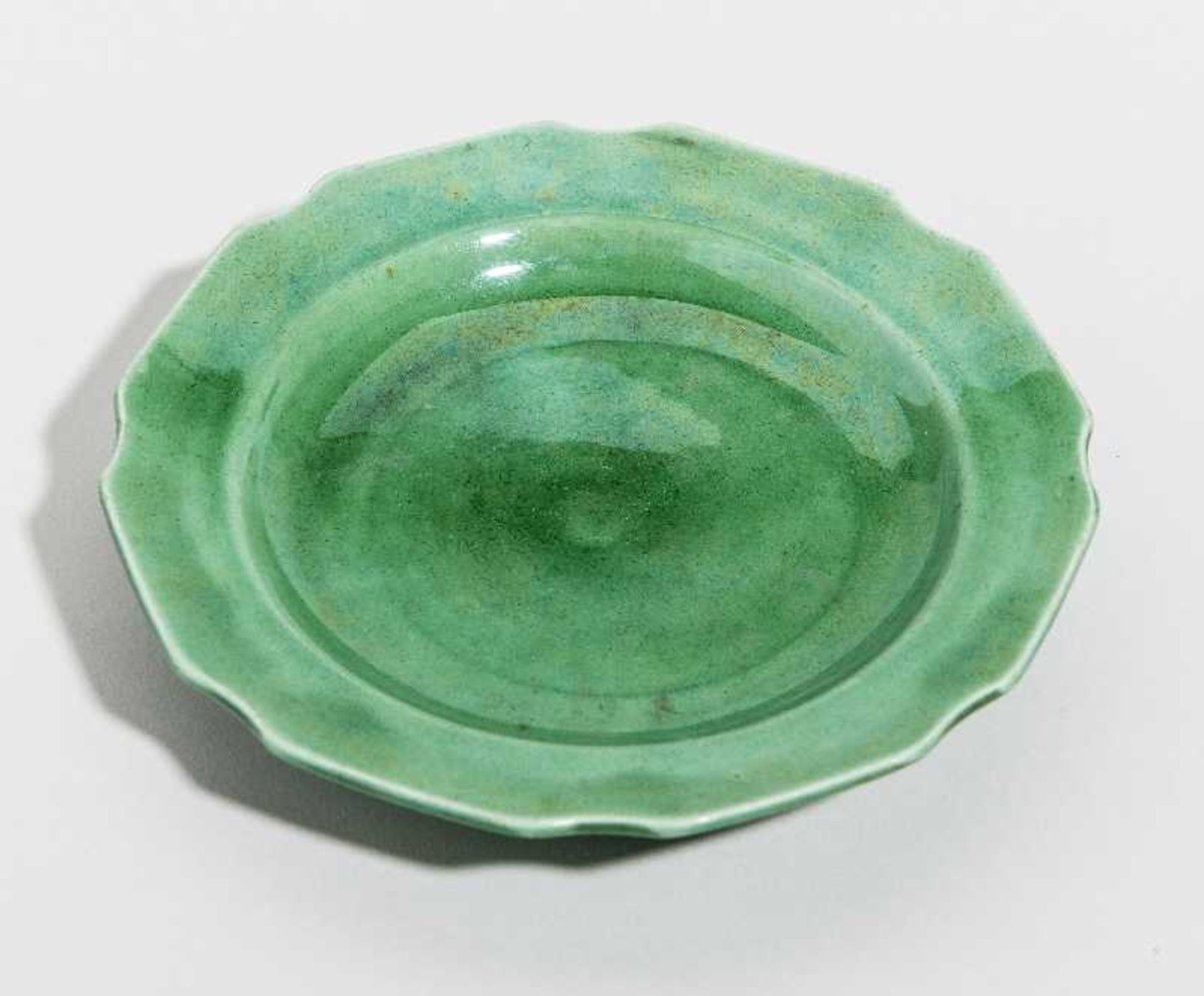 KLEINER TELLER Grün glasiertes Porzellan. China, Qing-Dynastie, 19. Jh. Oktogonaler Rand, jeweils