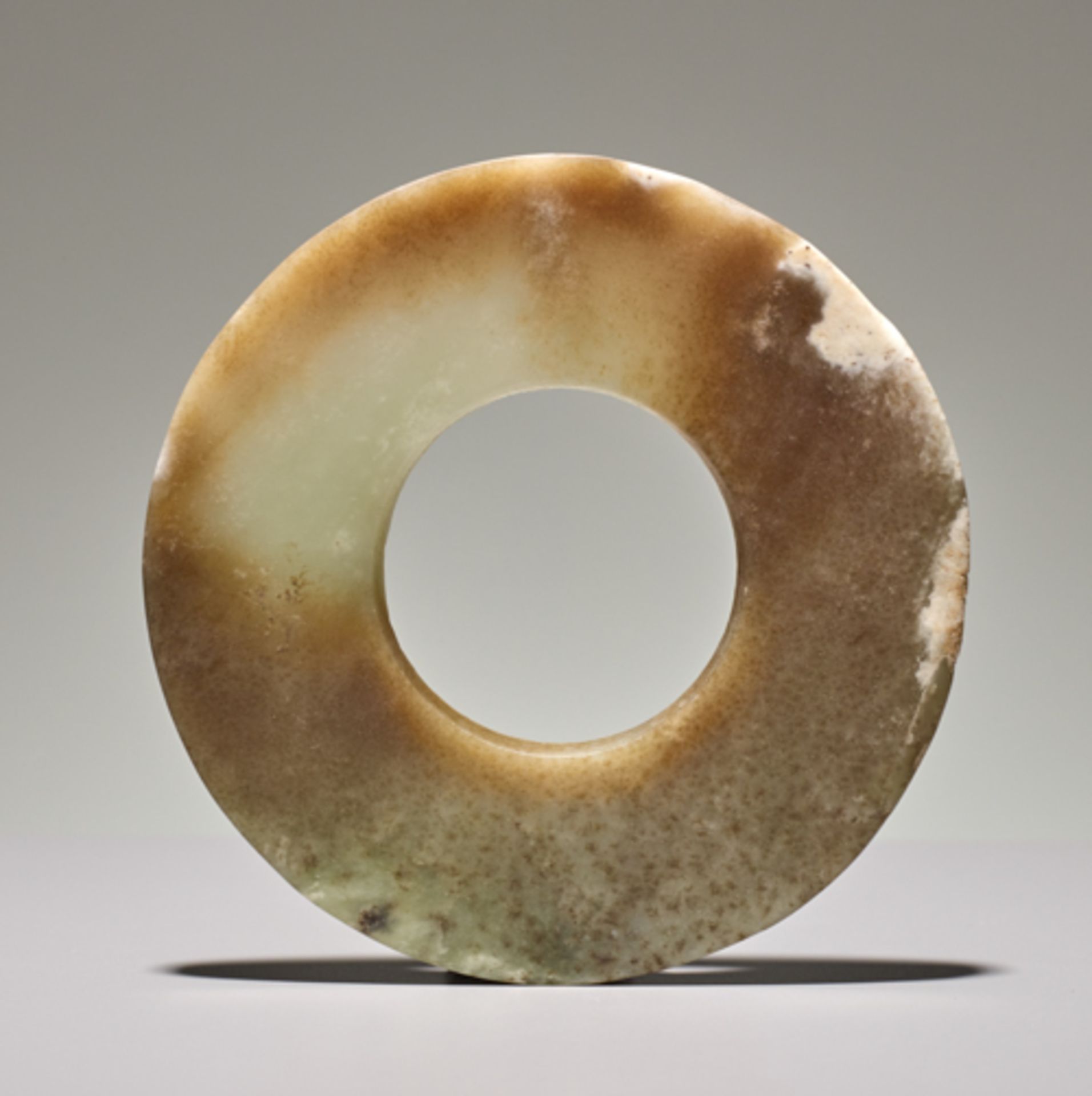 DISC IN SEMI-TRANSLUCENT JADE Jade. China, Late Neolithic period, Qijia culture, c.2200-1900 BC This