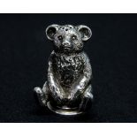 An Edwardian silver novelty pepperette in the form of a seated teddy bear, the body cast and chased,