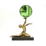 An Art Deco figural timepiece, the 7 inch green mirrored glass dial with convex markers,