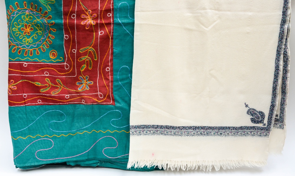 A cream hand woven shawl with hand embroidered decorative paisley design in blue/pinks/green,