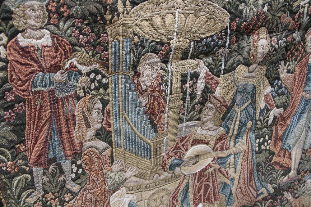 A large tapestry hanging, possibly called 'Concert by the Fountain',