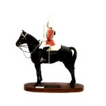 Beswick figurine of a lifeguard mounted on horseback with drawn sword.