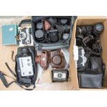 A collection of vintage cameras and lenses including a Pentax K1000,