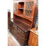 A Jacobean style oak dresser, the rack with two glazed doors and shelves,