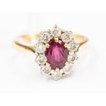 A ruby and diamond oval cluster 18 ct gold ring, the central ruby approx,