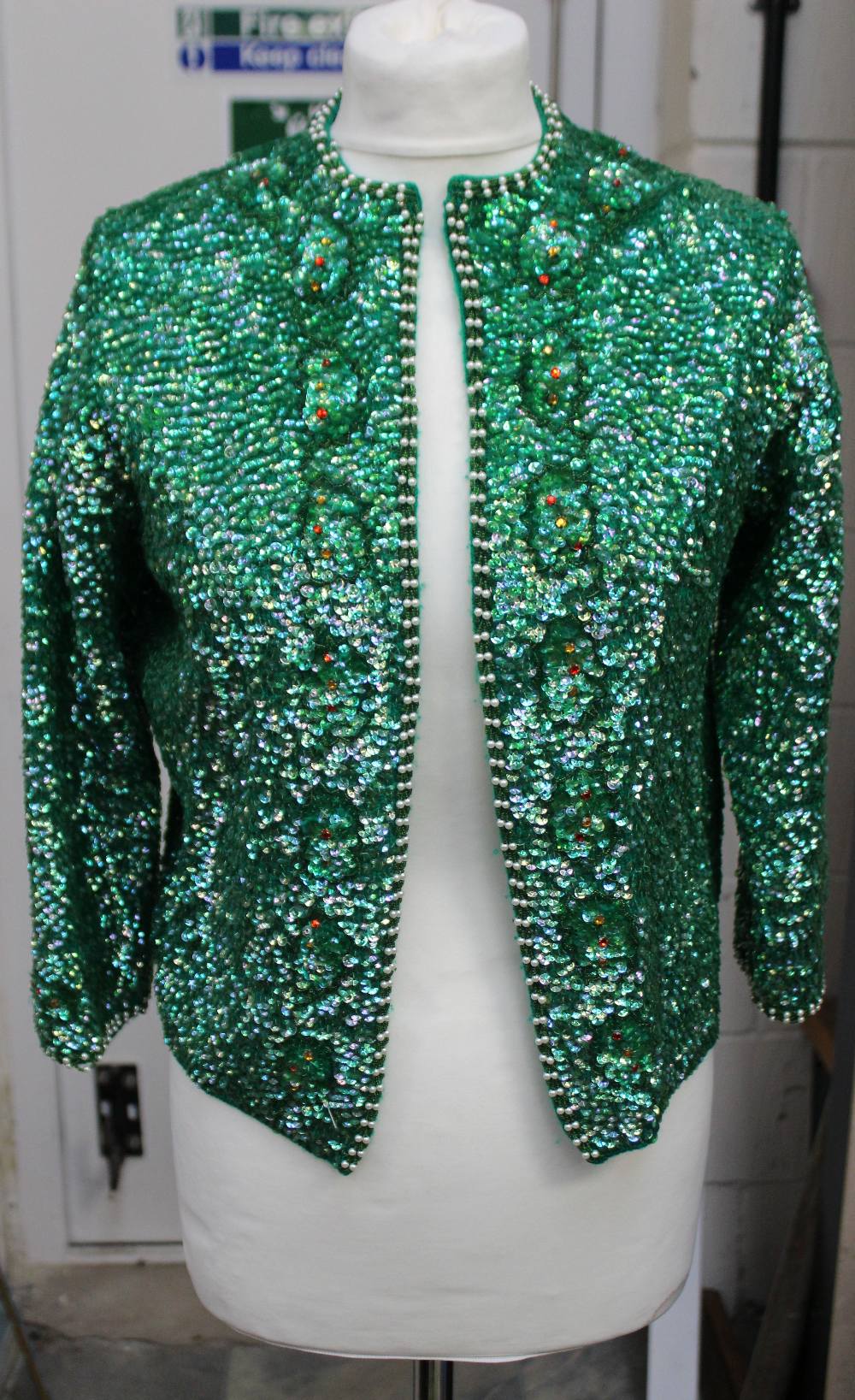 A vintage 1960s ladies' green-sequinned long sleeved evening jacket with seed pearl trim