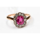 A ruby cluster ring to the centre within a border of twelve rose cut diamonds,