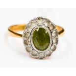 A 22 ct gold ring set with a central peridot surrounded by diamonds finger size P