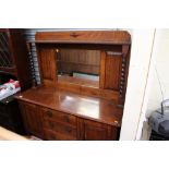 A George V oak sideboard, with mirror back, the base having three drawers and two doors,