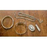 A collection of silver jewellery to include two bangles, watch chain and two Victorian brooches,
