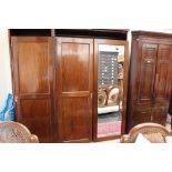A late 19th Century mahogany triple sectioned wardrobe, with a mirrored door,