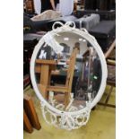 A Victorian oval wall mirror, one white painted frame with ribbon motif to the top,