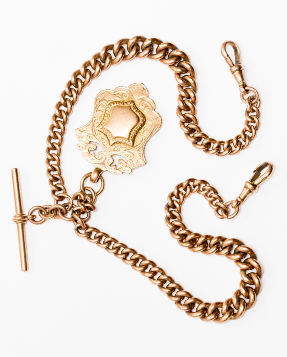 A 9ct gold Albert chain with scroll, links marked, suspended with a cartouche fob,