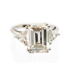 A solitaire diamond white metal ring, claw set emerald-cut diamond,