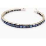 An Art Deco sapphire and white metal bracelet, square and rectangular channel set sapphires,