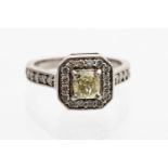 A diamond cluster ring, the central natural fancy light yellow diamond weighing approximately 0.