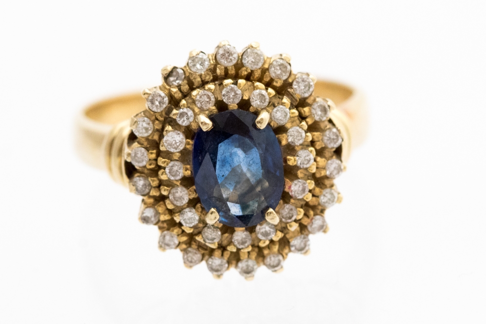 A sapphire and diamond two tier oval cluster ring, the central oval sapphire approximately 7.