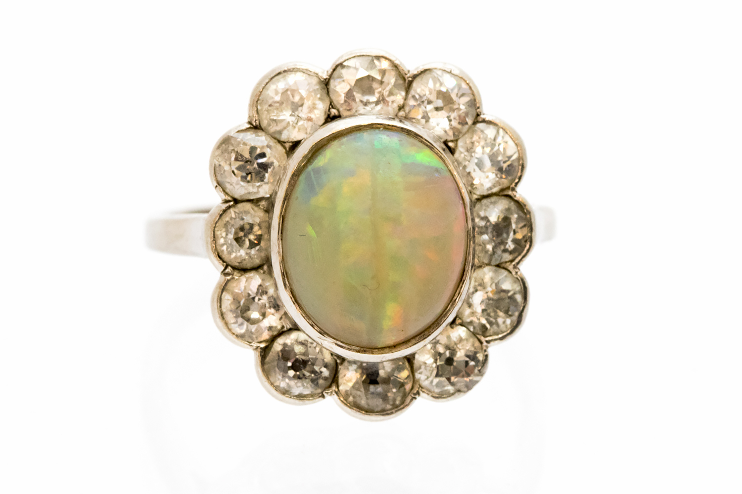 An opal and diamond oval cluster ring, the central opal 11mm by 9mm,