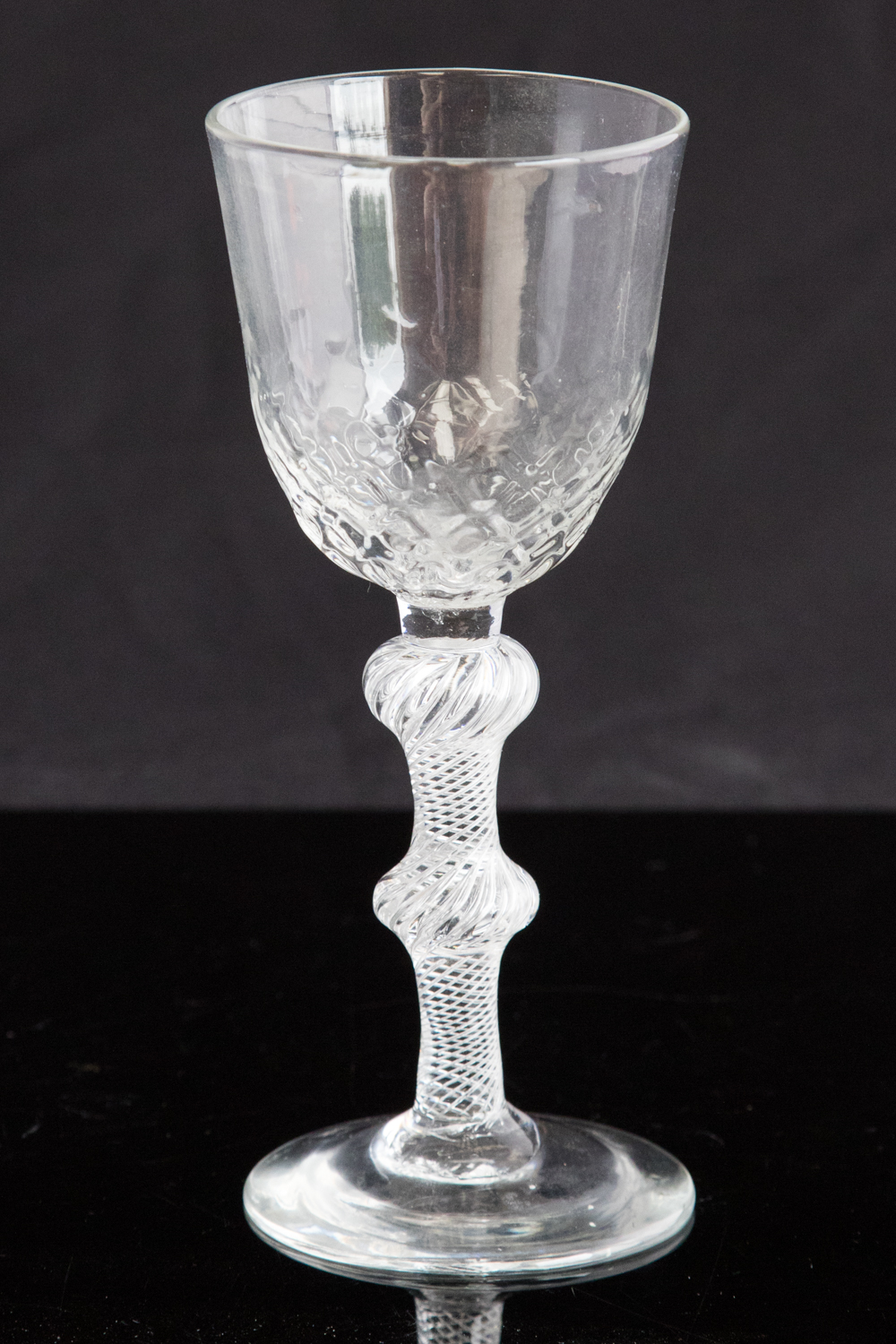 An 18th century balustroid wine glass, circa 1750, the optic moulded round funnel bowl,