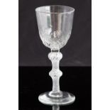 An 18th century balustroid wine glass, circa 1750, the optic moulded round funnel bowl,