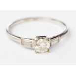 An Art Deco diamond solitaire platinum ring with diamond set shoulders,