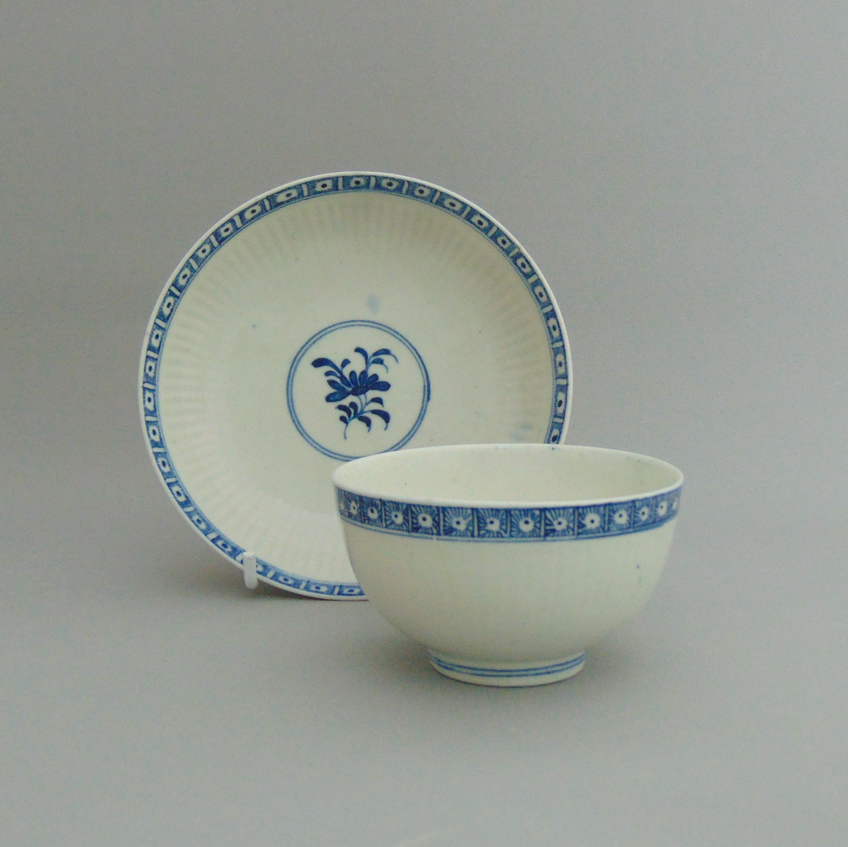 A Lowestoft tea bowl and saucer, blue borders with a dark sprig centre, circa 1760,