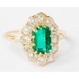 An emerald and diamond cluster yellow metal ring,