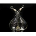 A George V glass intertwined oil and vinegar bottle with silver collars, complete with stoppers,