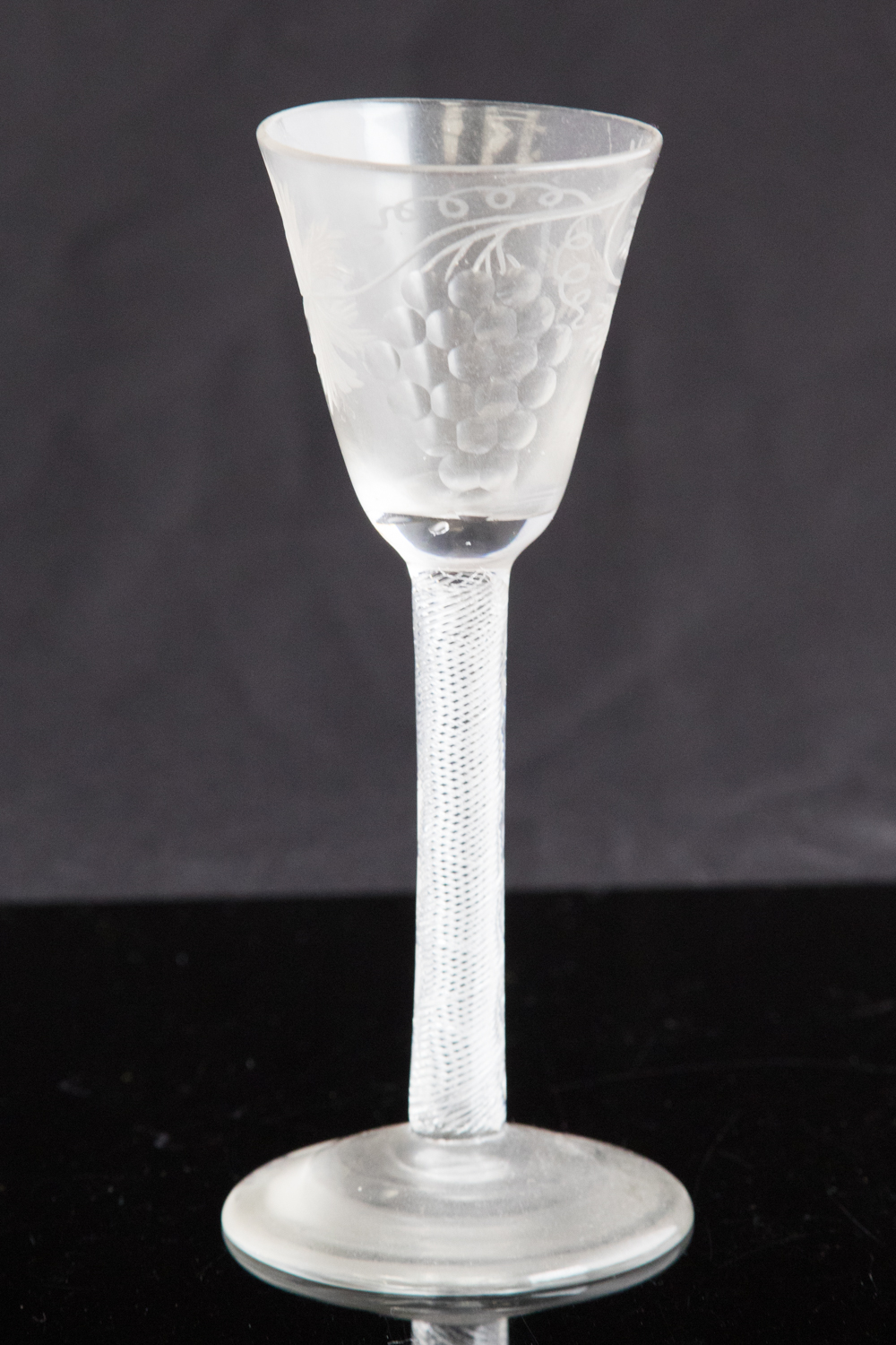 An 18th century wine glass, circa 1755, the round funnel bowl engraved with vine,